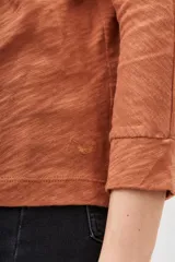 Remera azul de algodón peruano con textura jaspeada, de moldería holgada y buena caída, con mangas largas que se ajustan hacia la muñeca y se ensanchan debajo del brazo.