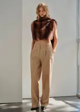 Pantalón de tiro medio color tostado, de corte recto y diseño largo con pinzas en la parte delantera y trabillas para cinturón. Cuenta con bolsillos laterales y cierre oculto.