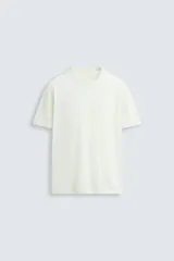Camiseta relaxed fit de punto ligero color blanco hueso, con cuello redondo y manga corta. Acabados en rib.