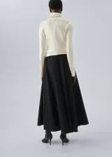 Falda larga evasé de tiro medio, color negro, confeccionada en mezcla de algodón y poliamida, con cintura elástica y bolsillos laterales.
