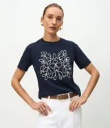 Remera de algodón color azul marino, con cuello redondo, mangas cortas y un bordado frontal en color blanco con diseño simétrico de motivos florales.