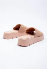 Sandalia color piel con tira ancha sobre el empeine y plataforma dentada de 4 cm de alto.