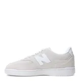 Championes urbanos New Balance modelo 080, color gris claro con detalles en blanco. Presentan una combinación de gamuza y malla en la capellada, con el logo "N" distintivo en los laterales y suela de goma blanca.