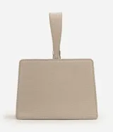 Cartera de mano Satinato de diseño rígido y estructurado, confeccionada en PU con textura croco de color beige. Cuenta con una manija superior corta, cierre con botón magnético y herrajes plateados.