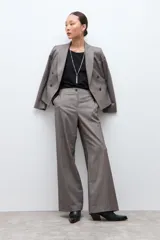 Pantalón sastrero de corte recto y tiro alto, confeccionado en tela con textura melange en tono beige. Presenta cierre frontal con botón y bolsillos laterales.