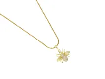 Cadena de acero con baño de oro y dije de bronce en forma de abeja, decorado con circonias brillantes.