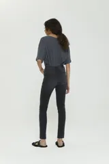 Pantalón skinny negro de tiro medio, confeccionado en denim premium con logo bordado en el bolsillo trasero.