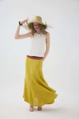 Falda larga de punto color mostaza, con cortes asimétricos, distintos puntos texturizados, ruedo irregular y pretina elástica con detalles en tono contrastante.