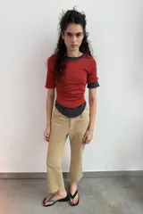 Camiseta de algodón color terracota con efecto lavado, cuello redondo y manga corta. Posee un bajo redondeado.