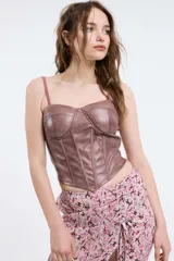 Bustier de cuero sintético en tono burdeos, con diseño estructurado tipo corsé, costuras verticales y escote corazón.