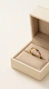 Anillo de plata 925 con baño de oro y diseño sin fin, engastado con circonias cuadradas en colores degradados que forman un arcoíris.