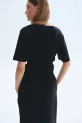 Remera entallada en punto fino de color negro, con hombros caídos, escote en U con ribete acanalado y mangas cortas amplias.
