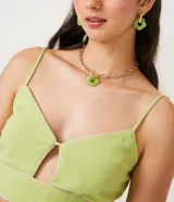 Blusa cropped color verde claro de lino con tirantes finos, escote en V con abertura en el pecho y ribete en color crema.