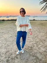 Sweater tejido en boucle color crema, de corte holgado y mangas largas.