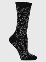Calcetín de caña media color negro con diseño tejido de ramas y hojas en color gris claro. El borde superior tiene un acabado festoneado.