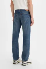 Jeans de denim azul con calce regular, tiro medio y bragueta con botones.