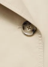 Chaqueta crop de doble botonadura color beige, con cuello pico con solapa, mangas largas y dos bolsillos laterales.