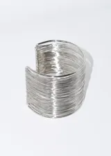 Pulsera brazalete rígido color dorado, con diseño de múltiples hilos finos.