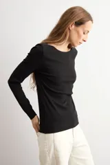 Remera de manga larga en color blanco, con escote bote y corte ajustado al cuerpo.