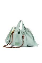 Cartera tipo tote de color verde agua, confeccionada en material sintético con acabado suave. Presenta un diseño fruncido en la parte superior, doble asa de mano y correa larga ajustable y extraíble. Incluye detalles de cordones decorativos trenzados en colores negro y naranja, y un parche frontal con el logo de la marca.