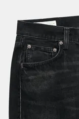 Jeans de tiro medio con corte straight, color azul con efecto lavado y roturas sutiles, cinco bolsillos y cierre frontal con cremallera y botón metálico.