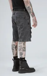 Bermuda de denim color negro con efecto acid wash y múltiples bolsillos cargo. Presenta un calce oversize y costuras marcadas.