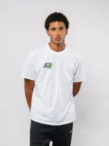 Remera de manga corta color blanco, con cuello redondo y logo de la marca estampado en color verde en el pecho.