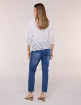 Camisa de calce holgado color blanco, confeccionada en tejido liviano de algodón, con cuello camisero clásico, mangas tres cuartos y terminación en puños y ruedo con diseño de bordado broderie calado y festoneado.