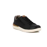 Championes casuales de cuero sintético color negro, con cierre lateral decorativo, cordones al tono y suela de goma color crema con detalle en marrón en el talón.