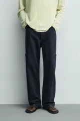 Pantalón cargo straight fit de algodón color negro con efecto lavado, bolsillos laterales en las piernas y cierre frontal con cremallera y botón.