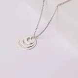 Collar de plata 925 con dije compuesto por tres aros concéntricos de diferentes tamaños y cadena de eslabones tipo veneciana.