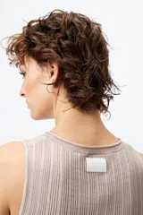 Musculosa blanca de tejido acanalado con detalle de trenzado lateral ajustable.