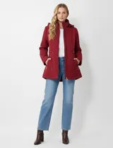 Campera acolchada color rojo oscuro (vino/bordó) con diseño capitoné en patrón de espiga (chevron). Posee cierre frontal, bolsillos laterales con cierre y capucha desmontable.