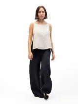Musculosa de lino color beige con escote redondo y laterales abiertos unidos por tres lazos cosidos.