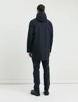 Gabardina con capucha de corte recto y largo medio. Cuenta con cierre frontal engomado, cartera con botones a presión, bolsillos laterales y tejido repelente al agua y al viento.
