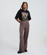 Pantalón wide leg de sastrería color marrón con diseño de raya de tiza, cintura fija con pliegues frontales y corte recto amplio.