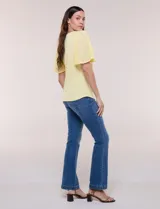 Blusa blanca de silueta suelta con escote redondo y mangas cortas estilo mariposa confeccionadas en tela plisada translúcida.