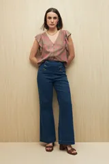 Jean de tiro alto con corte oxford, diseño de doble botonadura frontal y bolsillos laterales. Confeccionado en denim azul oscuro con costuras a contratono.