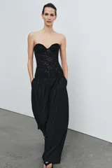 Corsé de encaje negro con escote corazón, hombros descubiertos y varillas interiores para estructura. Cuenta con cierre lateral mediante cremallera oculta.