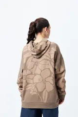 Canguro con capucha y bolsillo canguro frontal, de corte relajado. Presenta un estampado floral en tonos café y beige.