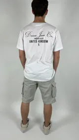 Remera blanca de algodón con estampado negro en el pecho con el texto "Duxon Jeans Co. Origin of Design United Kingdom" y una figura de ajedrez.