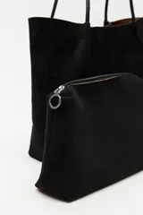 Cartera tipo shopper de gamuza color marrón, con diseño minimalista, formato amplio y asas largas para llevar al hombro.