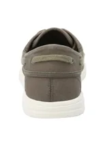 Zapatilla náutica de lona color marrón con cordones y suela blanca.