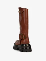 Bota de cuero color marrón con caña alta, hebillas decorativas y suela track.