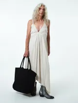 Vestido largo confeccionado en mezcla de lino y viscosa, con escote en V profundo, tirantes finos y espalda baja. Posee un diseño fluido con bajo asimétrico de caída en picos.