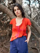 Blusa color naranja de gasa pintada con cuello asimétrico y mangas cortas.