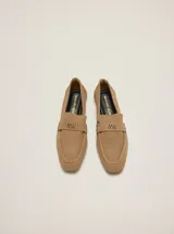 Mocasines de gamuza color tostado, de punta fina y diseño clásico, con detalle de antifaz en el empeine con el logo de la marca grabado.