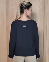 Remera de manga larga color blanco, con cuello redondo y dos bolsillos frontales tipo parche. Presenta un corte recto y holgado con un diseño minimalista.