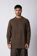Sweater marrón de punto con cuello redondo y mangas largas raglán. Tejido grueso con textura acanalada. Corte holgado.