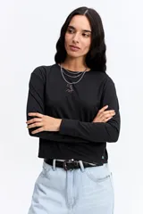 Remera de manga larga color negro, con silueta levemente boxy y largo a la cintura. Presenta una estampa lineal de una flor en el centro del pecho.